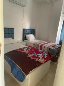 a bedroom with two beds with blankets on them at شاليه أرضي بجنينه في مارينا وادي دجله العين السخنه Three Bedroom Chalet with Garden In Marina Wadi Degla Ain El Sokhna - For Families Only in Ain Sokhna