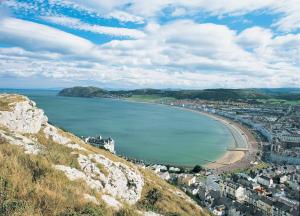 a view of a city and a beach on a hill at No 27 Chapel Street Guest House in Llandudno
