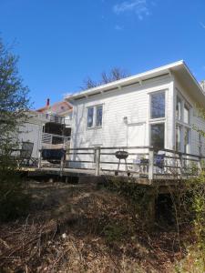 Åsarna Hills Holiday Home Stillingsön في Stillingsön: منزل متنقل مع شرفة وسطح