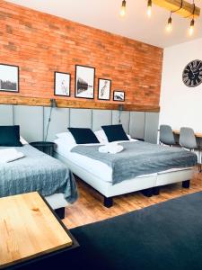 a bedroom with two beds and a brick wall at Pokoje i Apartamenty Donia in Ustroń