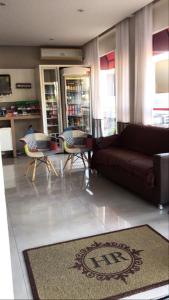 a living room with a brown couch and chairs at Hotel Requinte in Dois Vizinhos