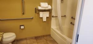 a bathroom with a toilet and a shower with towels at Candlewood Suites Champaign-Urbana University Area, an IHG Hotel in Champaign