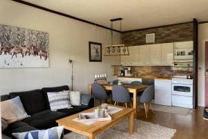 ein Wohnzimmer mit einem Sofa und einem Tisch sowie eine Küche in der Unterkunft Beste beliggenhet på Geilo. in Geilo