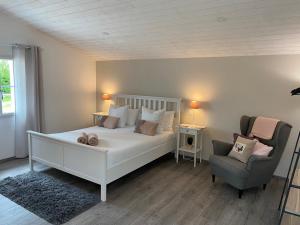 サン・ジャン・ド・モンにあるLa belle étoile chambres d'hôtesのベッドルーム(白いベッド1台、椅子付)