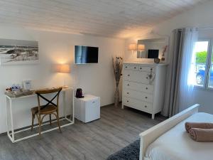 a bedroom with a bed and a desk and a dresser at La belle étoile chambres d'hôtes in Saint-Jean-de-Monts