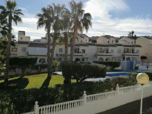 a view of a resort with palm trees and a fence at Casa Laurent in Gran Alacant