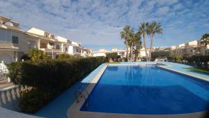 une grande piscine bleue en face de certains bâtiments dans l'établissement Casa Laurent, à Gran Alacant