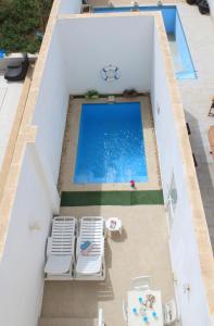 an overhead view of a swimming pool with two lawn chairs at Il-Qastna Holiday House in Żejtun