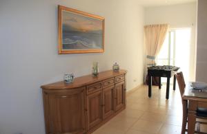 - un salon avec une armoire en bois et une table dans l'établissement Il-Qastna Holiday House, à Żejtun
