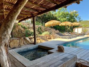 a swimming pool with umbrellas next to a swimming poolasteryasteryasteryastery at CASA IB in Peri