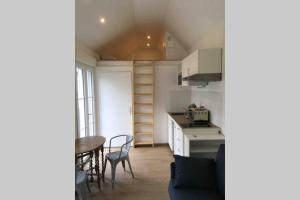 a small kitchen with a table and chairs in a room at Studio sauna, Homes d'Opale in Saint-Martin-Boulogne