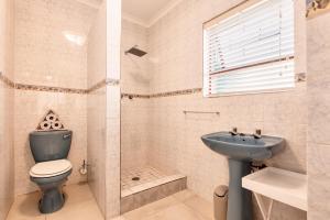a bathroom with a toilet and a sink and a shower at Perlemoen Retreat in Herolds Bay