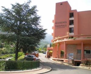 un edificio con un coche aparcado delante de él en Les Thermes de Vernet-les-bains en Vernet-les-Bains