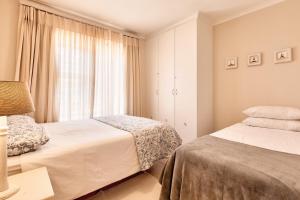 a bedroom with two beds and a window at Perlemoen Retreat in Herolds Bay