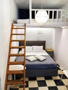 a bunk bed with a ladder in a room at Bougainvillea Friends & Family Studio - Old Town in Mikonos