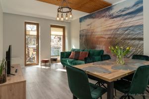 sala de estar con sofá verde y mesa en Aquarius Baltico Apartment en Ustka