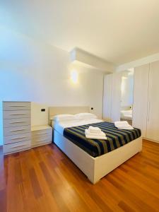 Margherita 8 Apartments في ريميني: غرفة نوم بسرير وبطانية بيضاء وسوداء