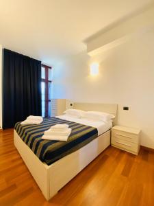 a bedroom with a bed with towels on it at Margherita 8 Apartments in Rimini