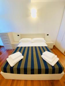 a bedroom with a bed with blue and yellow stripes at Margherita 8 Apartments in Rimini