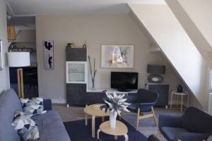 ein Wohnzimmer mit blauen Sofas und einem TV in der Unterkunft Les Mansardes du centre ville ,vue Loire in Blois