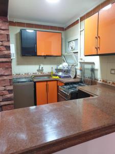 a kitchen with orange cabinets and a counter top at Sea point apartment in Alexandria