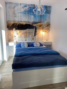 a bedroom with a bed with a blue comforter at Apatrament Krewetka in Rowy
