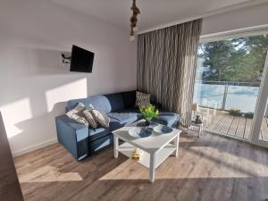 a living room with a blue couch and a table at Apatrament Krewetka in Rowy