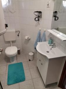 "ハルカーニャ"にあるAida apartmanの白いバスルーム(トイレ、シンク付)