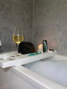 a glass of wine sitting on a shelf in a bath tub at Harbour View & Beach 50m from doorstep! in Nairn
