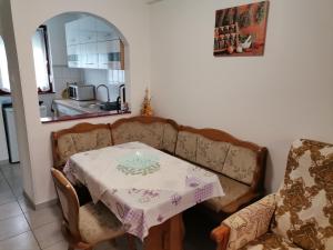 ein Zimmer mit einem Tisch und einem Sofa sowie einem Tisch und Stühlen in der Unterkunft Aida apartman in Harkány