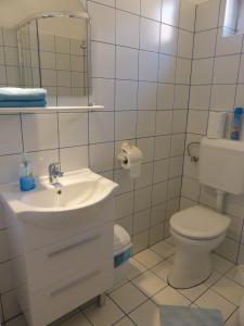 a white bathroom with a toilet and a sink at Napfény Apartman és Vendégház in Egerszalók +55 photos
