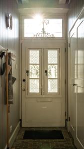 a white door in a hallway with a window at Traditional family apartment with garden at countryside Amsterdam in Landsmeer