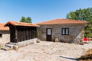 una piccola casa in pietra con una porta nera di Partezins 2 a Castelo de Paiva
