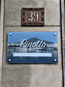un panneau sur le côté d'un mur avec un panneau pueblo dans l'établissement PINOTTO BNB, à Torre Annunziata