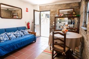 un soggiorno con divano blu e tavolo di Partezins 2 a Castelo de Paiva