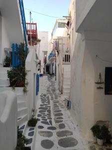 a narrow alley with white walls and cobblestone streets at Bougainvillea Friends & Family Studio - Old Town in Mýkonos City