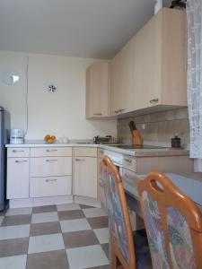 a kitchen with white cabinets and a table and chairs at Dedin raj in Golubac