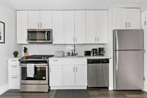 a kitchen with white cabinets and stainless steel appliances at Completely Set-Up 3BR Apt near Shops & Dining! - Lincoln 3 in Chicago