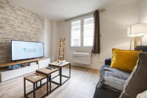 a living room with a couch and a tv at La Balade Nîmoise Center Car Park AC in Nîmes