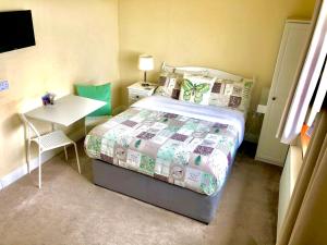 a small bedroom with a bed and a table at Ocean View Guestrooms in Doolin