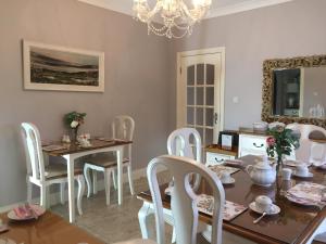 a dining room with a table and chairs and a chandelier at Laburnum B&B in Kenmare