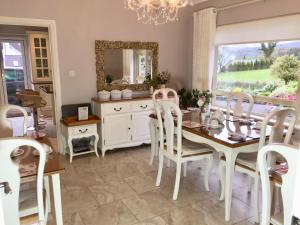 a dining room with a table and chairs and a mirror at Laburnum B&B in Kenmare