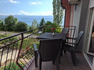 una mesa y sillas en un balcón con vistas al océano en Ajkoski Apartments Pestani en Ohrid