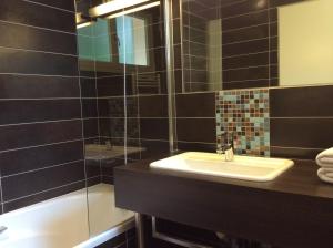 a bathroom with a sink and a shower at Hotel La Chaumiere in Dole