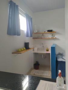 a room with a kitchen with a sink and shelves at Chalés Aconchego in Cavalcante