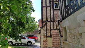 un coche aparcado en un aparcamiento al lado de un edificio en la maison du philosophe, en Amboise