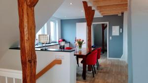 a kitchen and dining room with a table and red chairs at Villa Appartements Syke in Syke