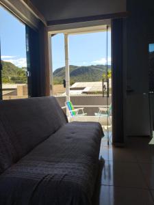 a bedroom with a bed and a large window at Chalés Aconchego in Cavalcante