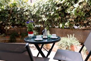 un piccolo tavolo nero con due tazze e un bollitore per il tè di Ecalù Siracusa a Siracusa