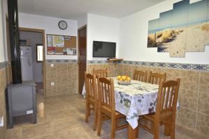 a dining room with a table with chairs and a television at Mas de Josep in L'Ampolla